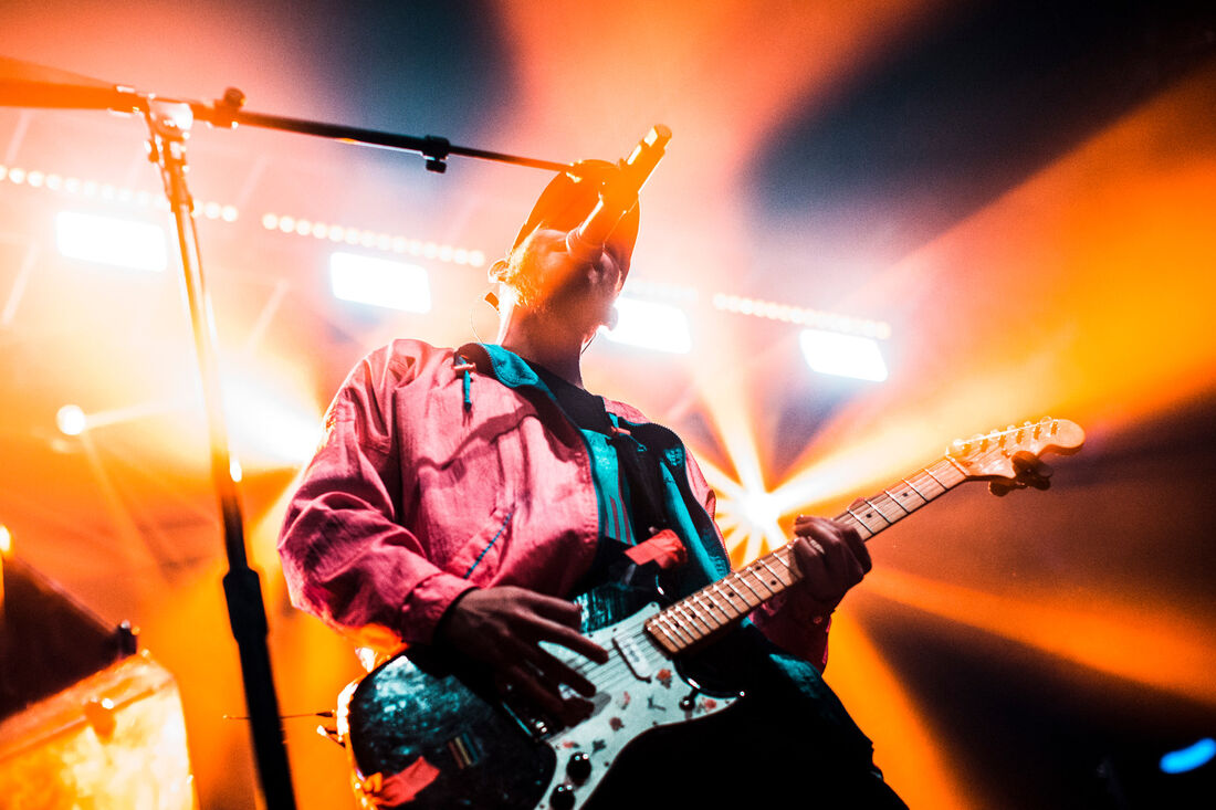 Guitarist under orange stage lights