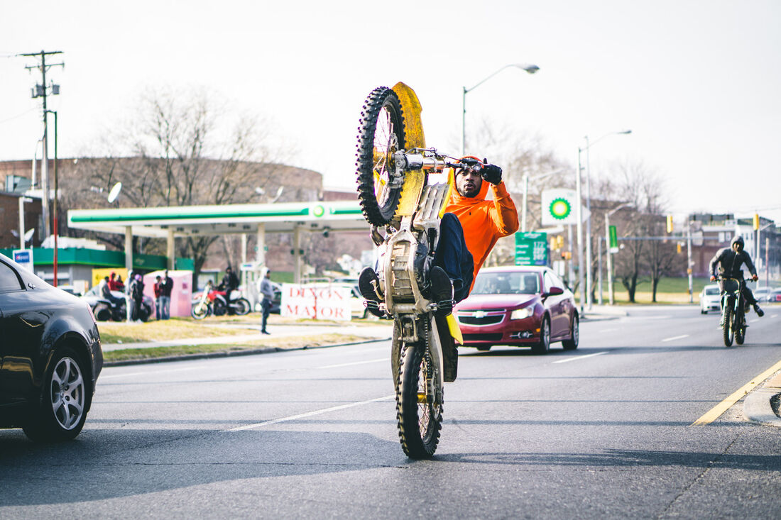 Wheelie past a gas station, Baltimore